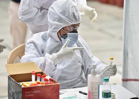 Medical professionals collect samples with PPE kit