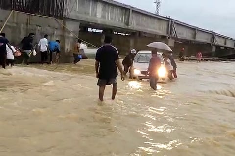 A car stuck in an overflowing stream in Mancherial district