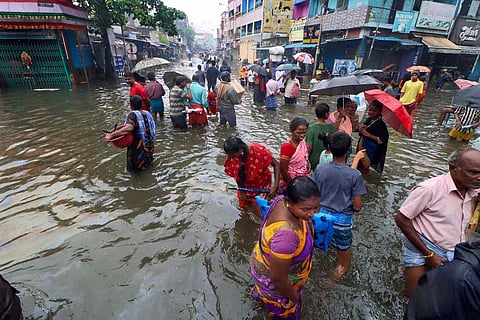 People wading through flooded street