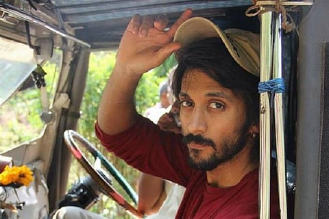 Chetan in a maroon t shirt holding his cap