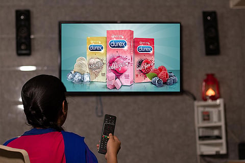 Child watching tv playing condom ad