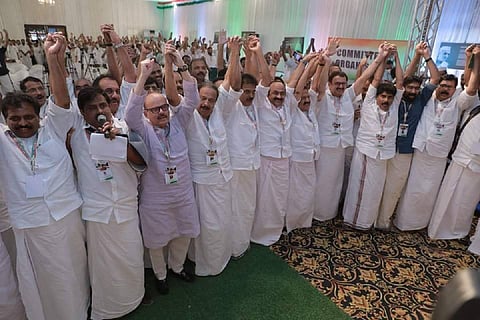 Congress leaders and cadre raising their hands in the meeting