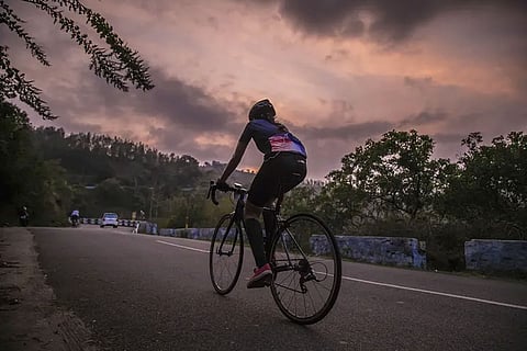 A person cycling alone on a road