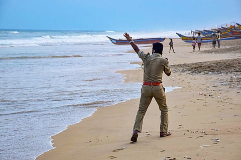 Cyclone Yaas: A file photo of a police personnel announcing cyclone related warnings at a beach