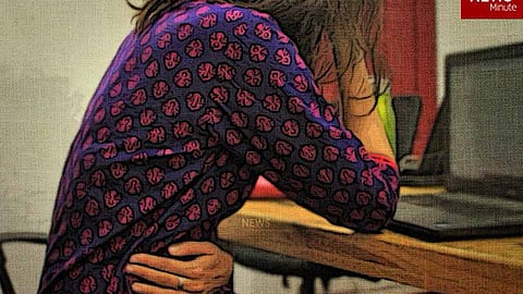 Image of woman sitting holding her stomach in pain