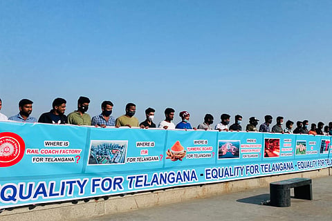TRS supporters hold up a banner demanding EqualityForTelangana at tank bund in Hyderabad