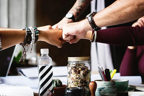 A group of people doing fist-bump
