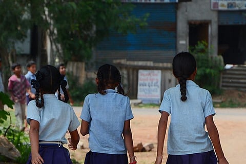 Three girl children in school uniform in a school campus