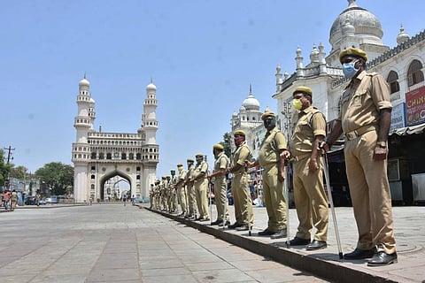 Telangana lockdown: A queue of policemen standing by the footpath with the Charminar in the background