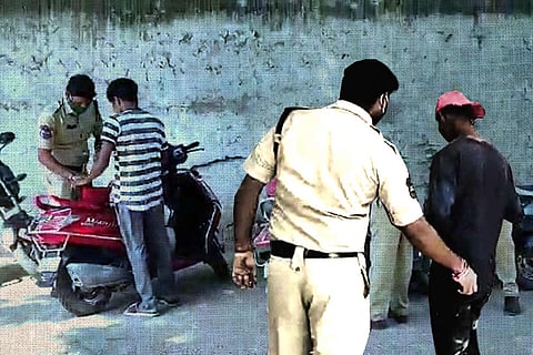 Police frisking youngsters travelling on a two-wheeler