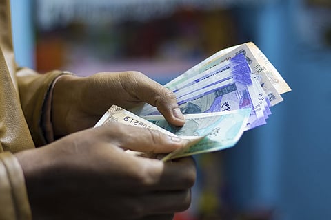 Representative image of a person counting Indian Rupee notes