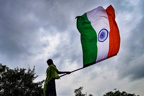 A person waving a large Indian flag