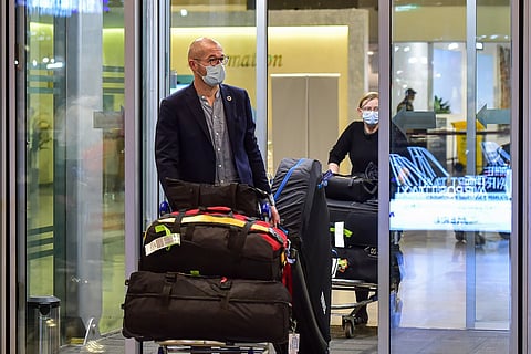 Representative image of a passenger walking out with luggage at an airport