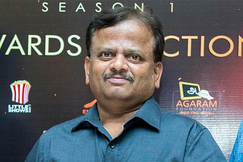 KV Anand in blue shirt at an award function