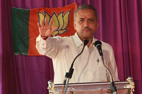 Vishweshwar Hegde Kageri in front of a BJP flag