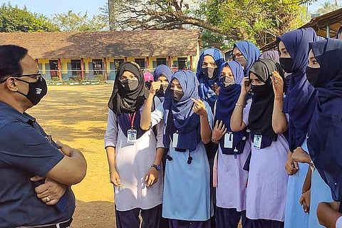 Muslim girls in hijab speaking to male teacher in Udupi