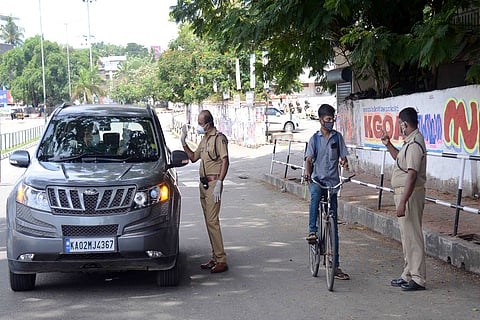 Police personnel checking a car during COVID-19 induced lockdown in Kerala