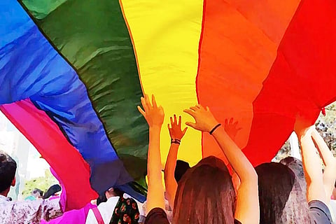 People holding up a pride flag