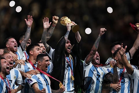 Lionel Messi wearing bisht holds aloft World Cup trophy