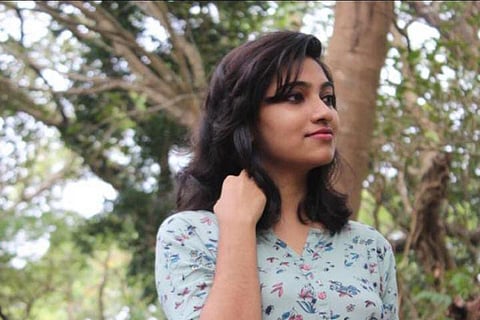 A girl in light blue kurta touching her hair