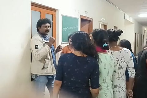 A screengrab from a video showing the teacher surrounded by angry girl students