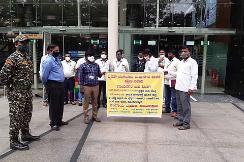 A group of people standing with a yellow coloured poster.