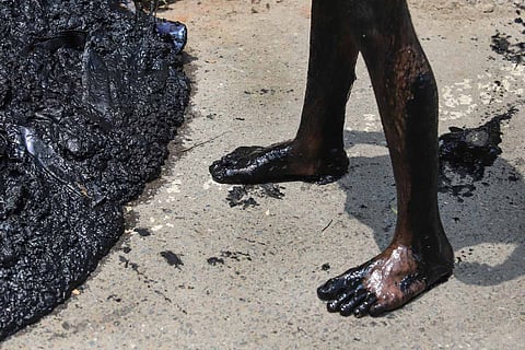 A manual scavenger cleans the chocked sewer