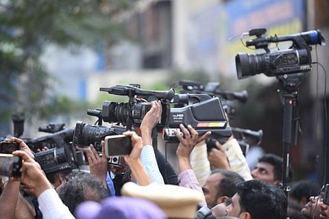 Video cameras and reporters in a press conference