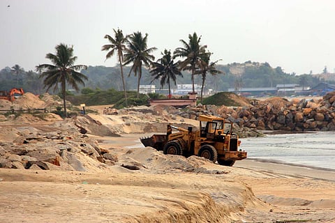 An earthmover dredging mineral sand along a coastal region at Thottappally in Alapuzha district of Kerala.