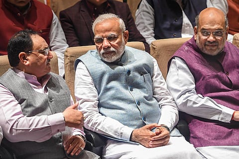 JP Nadda, Narendra Modi and Amit Shah seated next to each other engaged in a discussion