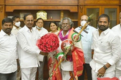 Telangana CM felicitating Mogulaiah with a bouquet and a shawl