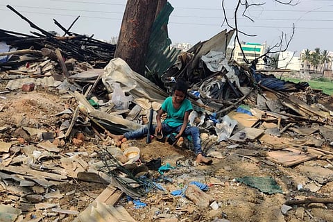 A small girl playing at the razed site while guarding their belongings