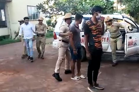 The accused being brought in a police car by cops