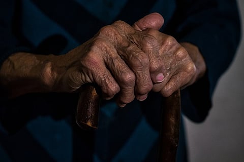 Elderly person holding walking stick