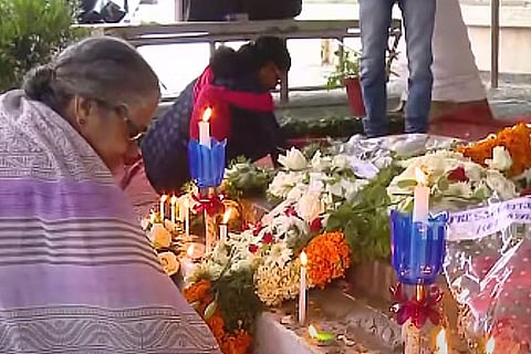 People burning candles in Kerala leader Oommen Chandy's tomb
