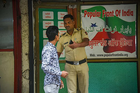 A representative image of a security official in front of a PFI office.