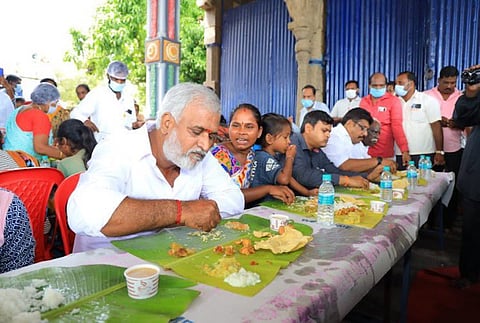 Sekar Babu eating as a woman sitting next to him speaks to him