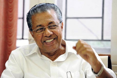 Pinarayi Vijayan wearing white shirt and laughing