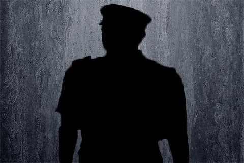 Shadow of a police officer against a grey background