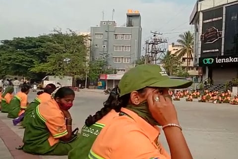 Pourakarmikas sitting on the roadside in protest in Bengaluru's Banaswadi