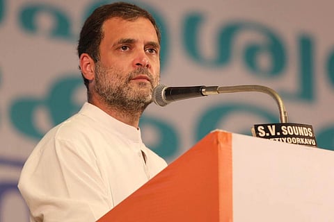 Rahul Gandhi wearing white and speaking over a mic