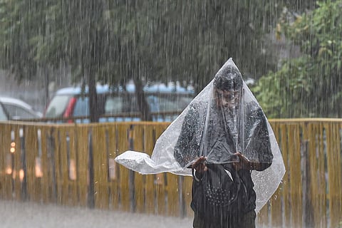 Representative image of a man wearing a raincoat, walking through rains
