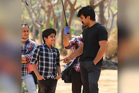 Ram Charan is seen speaking with a young boy in the image from the sets of RRR.