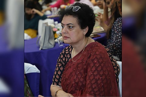 NCW Chairman Rekha Sharma wearing a black colored dotted blouse and maroon colored saree, facing sideways to the camera