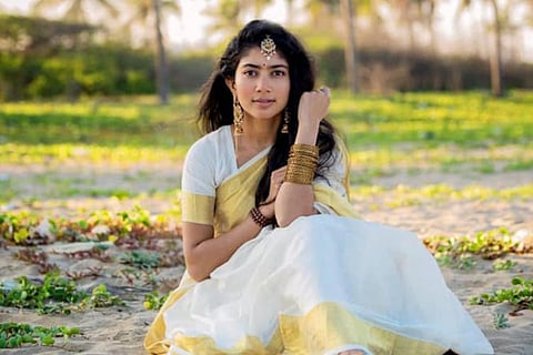 Sai Pallavi is seen wearing a kasavu saree and ethnic jewelry in the image.