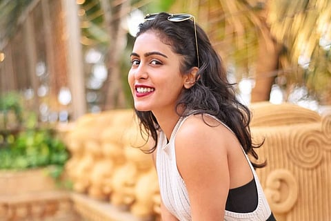 Actor Samyuktha Hegde is seen wearing a white top and is seen smiling at the camera in the photo.