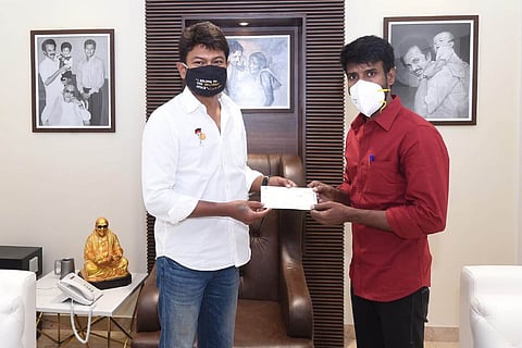 Soori is handing over a cheque to Udhayanidhi Stalin.