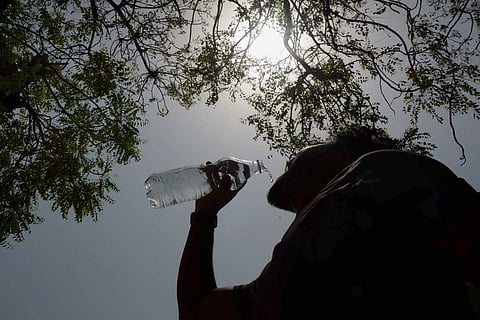 A person drinking water under the sun