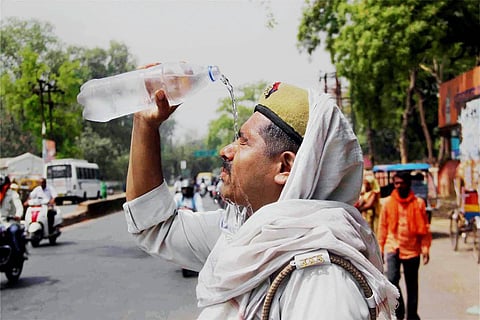 Bengaluru weather: A policeman tries to escape the scorching heat by pouring water on his face