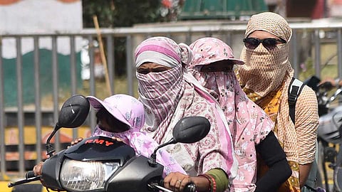 Women on a scooter wearing scarves in summer as Telangana recorded 43C in some regions